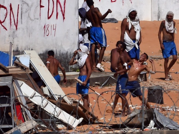 19/01 - Presos atiram pedras durante um confronto de facções na penitenciária de Alcaçuz, perto de Natal, no Rio Grande do Norte (Foto: Josemar Gonçalves/Reuters)