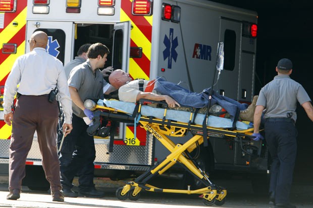 Ferido é socorrido após tiroteio nesta quinta-feira (24) em Millington, no Tennessee (Foto: AP)