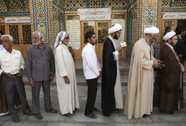 Homens fazem fila para votar em mesquita em Qom, ao sul de Teerã, nesta segunda-feira (14) (Foto: Mohammad Akhlagi/Far News/Reuters)