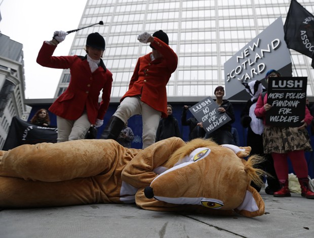 Manifestantes fingem bater em raposa em protesto realizado em Londres, na Grã-Bretanha (Foto: Lefteris Pitarakis/AP)