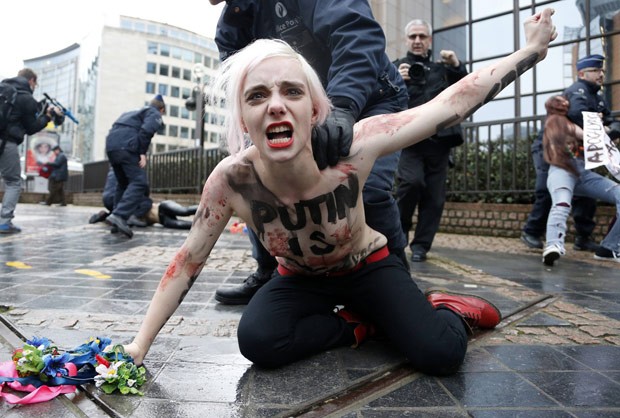 Seminuas, ativistas protestam contra presidente russo em Bruxelas nesta sexta-feira (21) (Foto: Reuters)