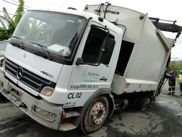 Caminhão fica preso em buraco de rua em Passos. (Foto: Helder Almeida / Clic Folha)