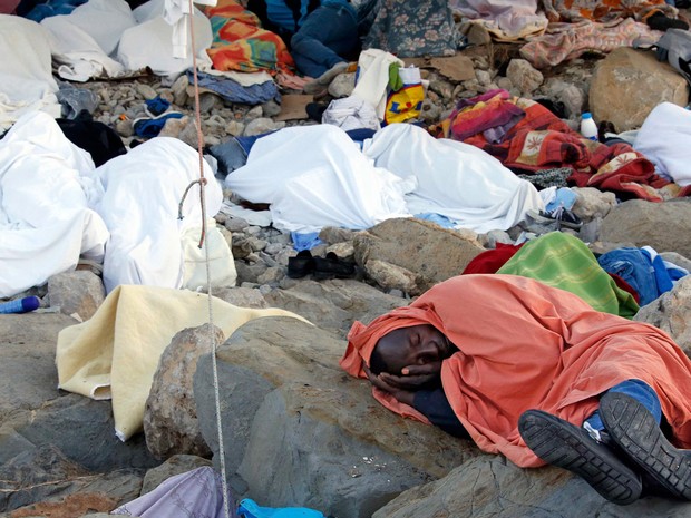Imigrantes dormem coberto por cobertores sobre as rochas do paredão da passagem na fronteira de Saint Ludovic, no Mar Mediterrâneo, entre a Itália e a França. Na terça (17) a polícia começou a retirar os imigrantes, na maioria do Sudão e Eritreia, do loca (Foto: Eric Gaillard/Reuters)