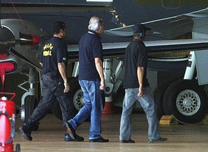 José Dirceu desembarca em Brasília, acompanhado por policiais federais (Foto: André Coelho/Agência O Globo)