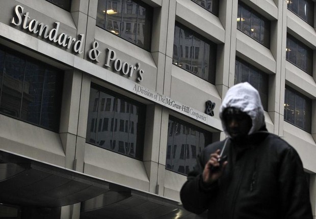 Homem caminha diante da sede da agência classificatória de risco Standard &amp; Poor&#39;s em Nova York (Foto: Brendan McDermid/Reuters)