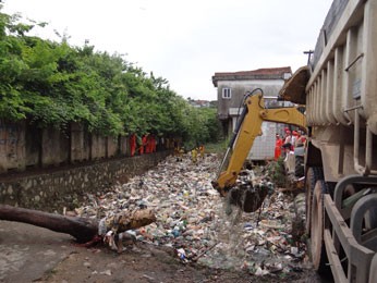 Retroescavadeira recolhe lixo do rio (Foto: Luna Markman/ G1)