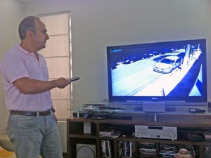 Mansour também observa as imagens das câmeras de vigilância pelo monitor da residência (Foto: Tatiana Santiago/G1)