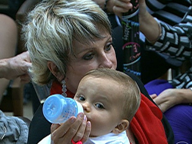 Vovó-coruja, Ana Maria dá mamadeira durante batizado do netinho Bento (Foto: Mais Você / TV Globo)