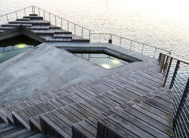 Detalhe do ponto de encontro Hasle Havsbad. A estrutura criada em um lago na Dinamarca conta com arquibancada para tomar sol e recortes no deque que criam pequenas piscinas (Foto: White Arkitekter/Divulgação)