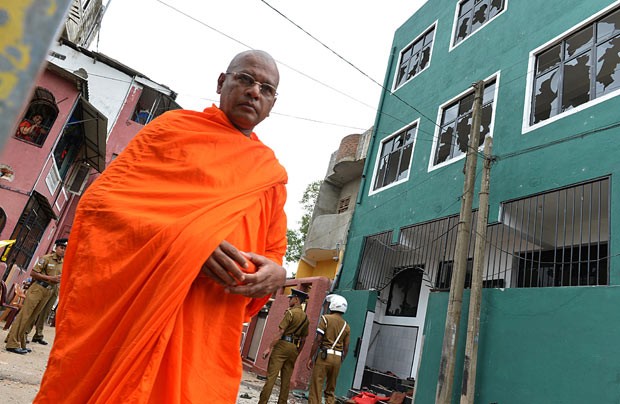 Monge budista em frente à mesquita vandalizada em Colombo, capital do Sri Lanka (Foto: Ishara S. Kodikara/AFP)