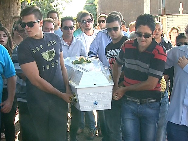 O cantor Gian (à direita) ajuda a levar o caixão da sobrinha até o túmulo em Franca (Foto: Márcio Meireles/EPTV)