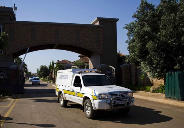 Van do serviço forense deixa propriedade em que fica a casa de Oscar Pistorius, nesta quinta-feira (14), em Pretória, na África do Sul (Foto: AFP)