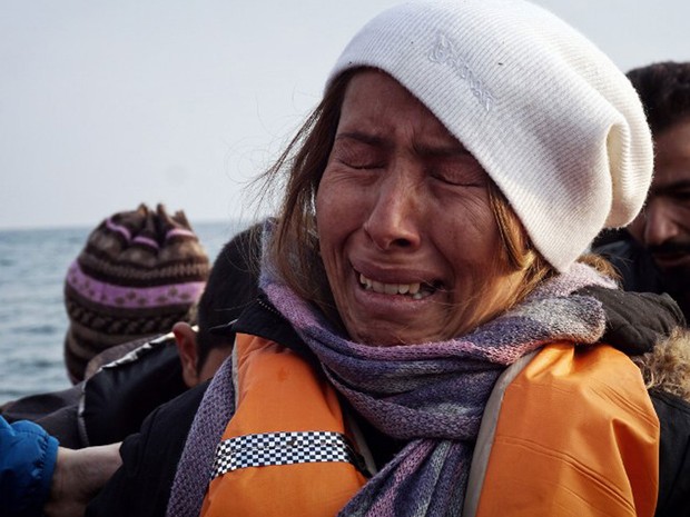 Mulher se emociona ao chegar em bote à Ilha de Lesbos, na costa grega, no domingo (20), quando novo acordo entre União Europeia e Turquia começou a valer (Foto: STR / AFP)
