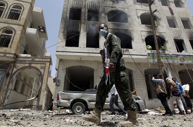 Iemenitas checam estragos causados por bombardeio contra base de msseis em Sanaa nesta segunda-feira (20) (Foto: Mohammed Huwais/AFP)