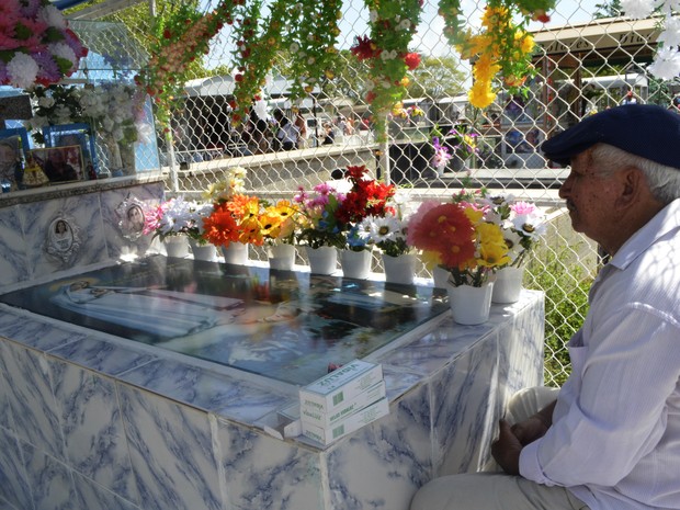 Roberto de Souza passar o Dia de Finados sentado em frente ao túmulo da esposa (Foto: Abinoan Santiago/G1)