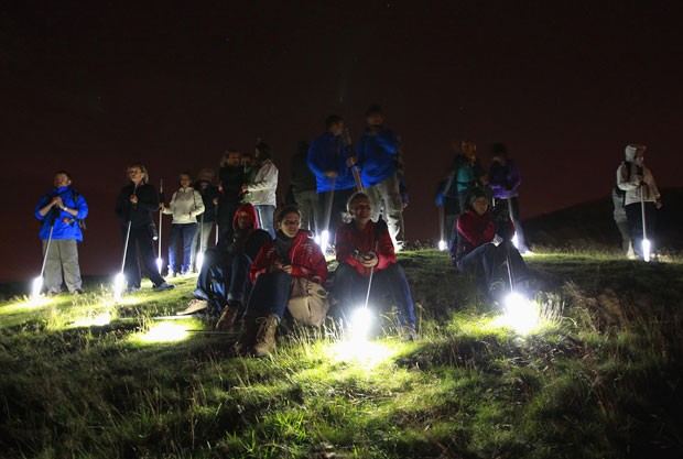 O público recebeu suas próprias varetas de luz para acompanhar o espetáculo no monte britânico (Foto: David Moir/Reuters)