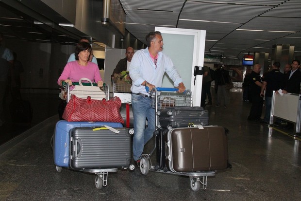 Glória Pires desembarca cheia de malas ao lado do marido, Orlando Morais (Foto: Gabriel Rangel e Delson Silva/Ag News)