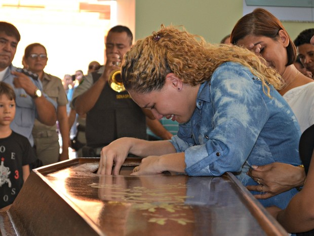 Mulher de PM morto chora em caixão durante velório em Rio Branco (Foto: Iryá Rodrigues/G1)