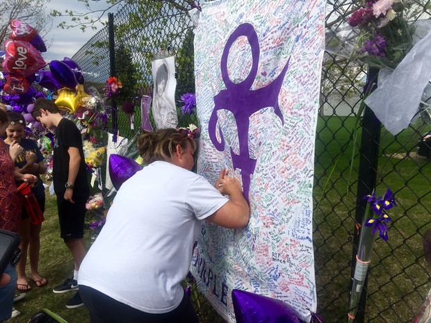 Homenagens em frente à casa de Prince neste sábado (23) (Foto: AP Photo/Jeff Baenen)