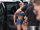 Miley Cyrus dá ajeitadinha no short para não mostrar demais
