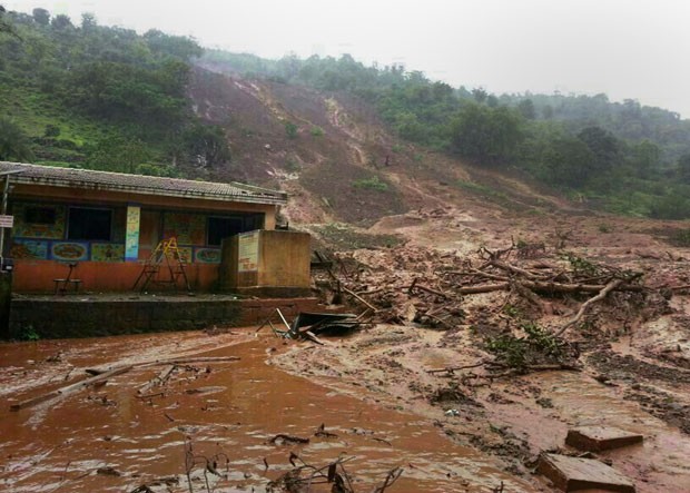 Deslizamento de terra é visto em vila no estado de Maharashtra, na Índia, nesta quarta-feira (30). Autoridades temem que 150 pessoas foram soterradas (Foto: AFP)