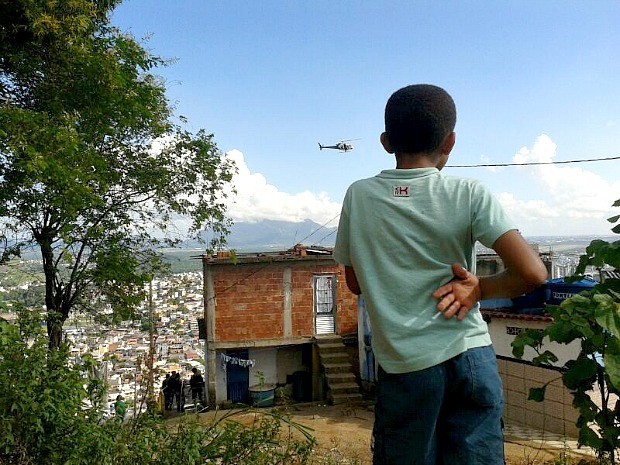 Menino observa ação da Polícia Militar durante ação em comunidades do Espírito Santo. (Foto: André Falcão/TV Gazeta)
