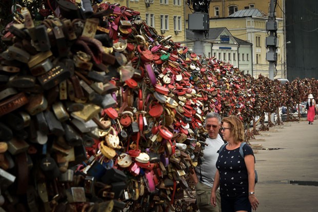 Casal passa por Ã¡rvores de metal que abrigam os cadeados do amor em Moscou (Foto: Kirill Kudryavtsev/AFP)