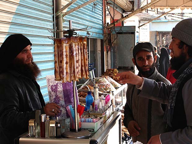 Jihadista do Estado Islâmico (direita) conversa com vendedor de perfume em rua da Raqqa, na Síria, em foto de setembro de 2014 (Foto: Militant website via AP) Jihadista do Estado Islâmico (direita) conversa com vendedor de perfume em rua da Raqqa, na Síria, em foto de setembro de 2014 (Foto: Militant website via AP)