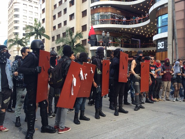 Mascarados vão à frente da manifestação. Grupo passa em frente da Galeria do Rock, no Centro. (Foto: Glauco Araújo/G1)