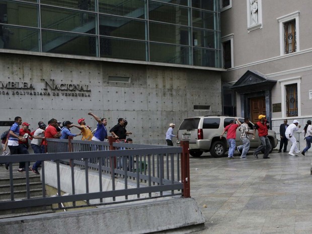 Chavistas e opositores brigaram nesta quinta-feira (7) em frente ao Conselho Nacional Eleitoral, em Caracas, por convocatória de referendo para encurtar mandato de Nicolás Maduro (Foto: REUTERS/Marco Bello)