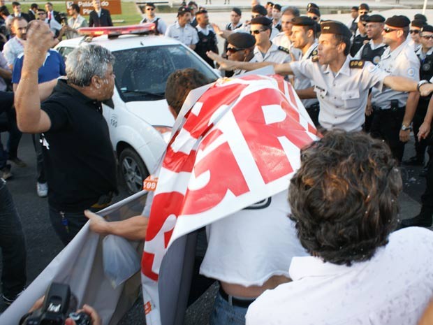 Servidor com cabeça coberta por spray de pimenta enfrenta policial em frente ao Palácio do Planalto durante manifestação nesta quarta-feira (8) (Foto: Vianey Bentes/TV Globo)