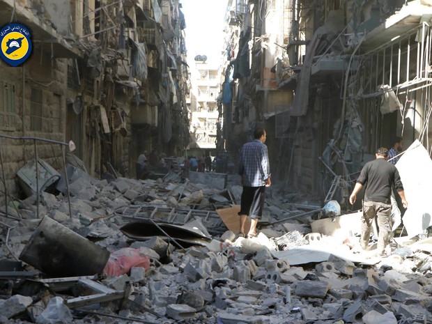 Sírios inspecionam edifícios destruídos após ataques aéreos em Aleppo (Foto: Syrian Civil Defense White Helmets via AP)