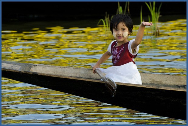 Uma menina navega, com um remo na mão, na ponta de uma canoa em um dos canais de um vilarejo flutuante do lago Inle (Foto: Haroldo Castro/ÉPOCA)