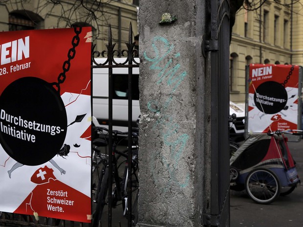 Cartazes contra a expulsão de expulsar delinquentes estrangeiros foram fixados em Bern, na Suíça (Foto: Ruben Sprich / Reuters)
