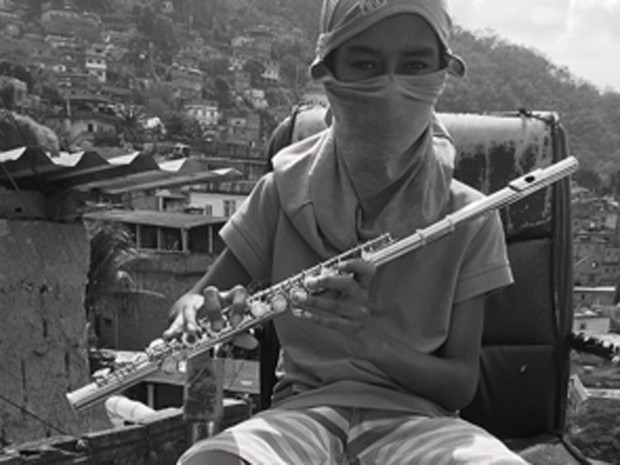 Menino toca instrumento musical na favela do Borel, na Tijuca (Foto: Anderson Valentim/Projeto Favelagrafia)