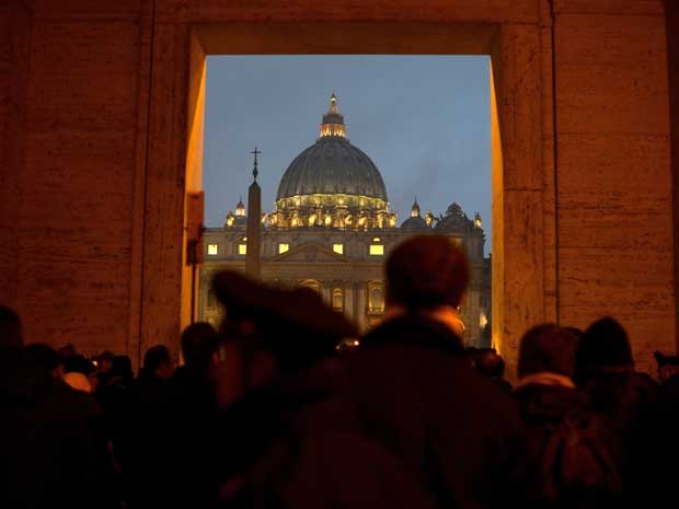 Pessoas se reúnem em frente a cúpula de São Pedro, no Vaticano, depois que o papa Bento XVI anunciou que vai renunciar ao cargo. (Foto: Filippo Monteforte / AFP Photo)
