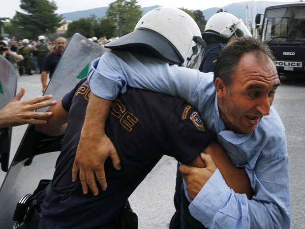  Vassilis Karakitsos, presidente da união dos trabalhadores dos estaleiros é detido durante confronto com a polícia, em Atenas. Os manifestantes exigiam o pagamento de salários atrasados a que diziam ser de direito.  (Foto: Reuters)