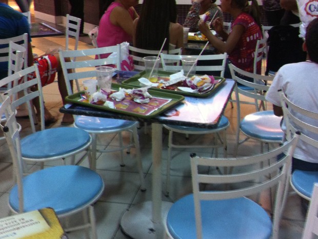 Pessoas deixam bandejas com restos de comida em cima das mesas de praça de alimentação de shoppings de Maceió (Foto: Fabiana De Mutiis/G1)