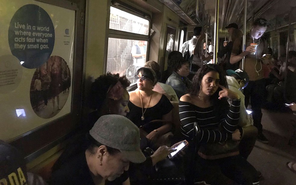 Passageiros são vistos em vagão sem iluminação após descarrilamento de trem do metrô perto da parada da rua 125 no Harlem, em NY, na terça (27) (Foto: Jackie Faherty via AP)