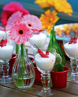 Flores em pequenas garrafas e taças com sal grosso formam um conjunto gracioso na mesa ou no aparador