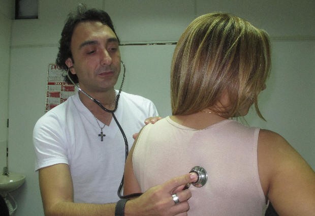 Médico cantor avalia paciente no Hospital Municipal de São Vicente (Foto: Matheus Misumoto/G1)