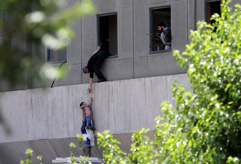 Criança é retirada pela janela durante ataque ao Parlamento do Irã, em Teerã, nesta quarta-feira (7)  (Foto: Omid Vahabzadeh/Tima via Reuters)