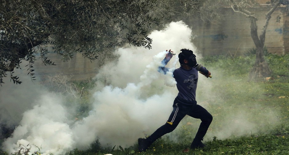 Palestino lança de volta bomba de gás lacrimogêneo atirada por soldados israelenses durante protestos contra vandalismos praticados por judeus moradores da região palestina de Nablus