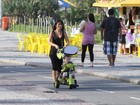 Daniele Suzuki empurra o triciclo do filho em passeio na orla do Rio