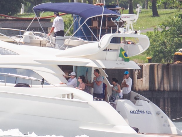 A presidente Dilma Rousseff (de boné branco) chega de um passeio no mar, na lancha Amazônia Azul, acompanhada de outras pessoas, na Base Naval de Aratu (BA), onde passa alguns dias de férias, neste domingo.  (Foto: Ed Ferreira / Estadão Conteúdo)