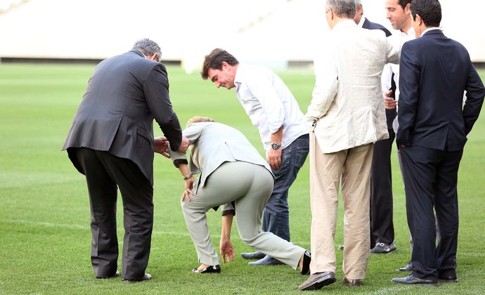 Dilma se desequilibra e quase cai ao se abaixar para checar a grama da Arena Corinthians (Foto: Marcos Ribolli)