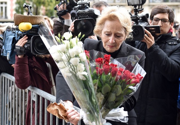 Mulher deixa flores em bloqueio perto do Bataclan, casa de shows que foi alvo de um ataque ontem em Paris. Mais de 120 pessoas morreram em ataques coordenados, de acordo com o gabinete da Presidência (Foto: Uwe Anspach/EPA/EFE)