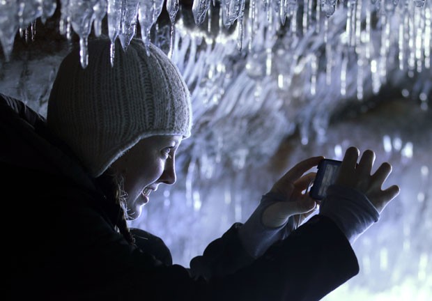 Visitante fotografa as formações de gelo (Foto: Brian Peterson/AP)
