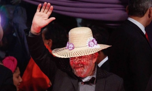 O ex-presidente Luiz Inácio Lula da Silva coloca chapéu das margaridas durante a abertura do ato no Estádio Mané Garrincha, em Brasília (Foto: André Coelho / Agência O Globo)