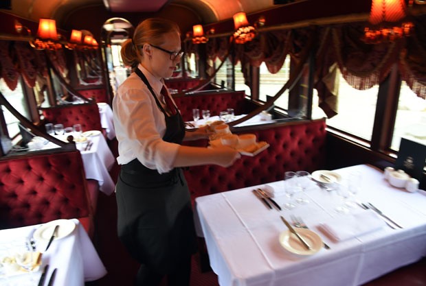 Garçonete passa por mesas do Colonial Tramcar Restaurant (Foto: Indranil Mukherjee/AFP)